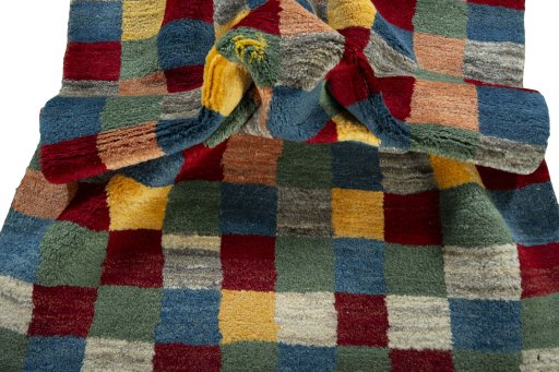 Corner detail of 2000s Persian Gabbeh rug showing border pattern and Wool pile