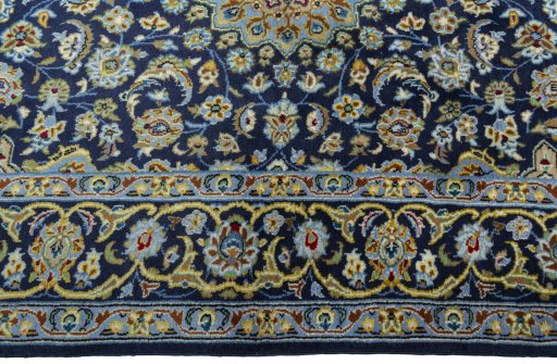 Corner detail of 2000s Kashan rug showing border pattern and Wool pile