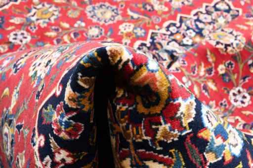 Backside of handmade 2000s Kashan rug showing knot structure and weave density