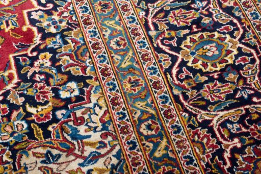 Corner detail of 2000s Kashan rug showing border pattern and Wool pile