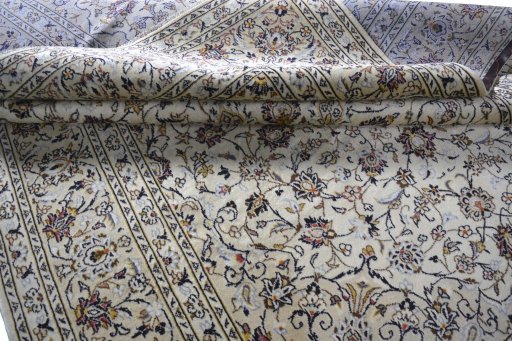 Corner detail of 2000s Kashan rug showing border pattern and Wool pile