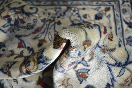 Backside of handmade 2000s Kashan rug showing knot structure and weave density