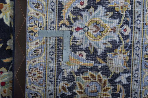 Backside of handmade 2000s Kashan rug showing knot structure and weave density