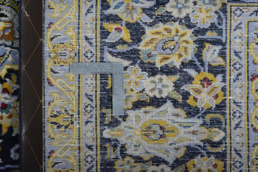 Backside of handmade 2000s Kashan rug showing knot structure and weave density