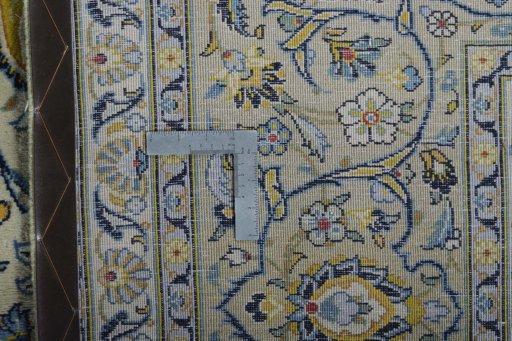 Backside of handmade 2000s Kashan rug showing knot structure and weave density