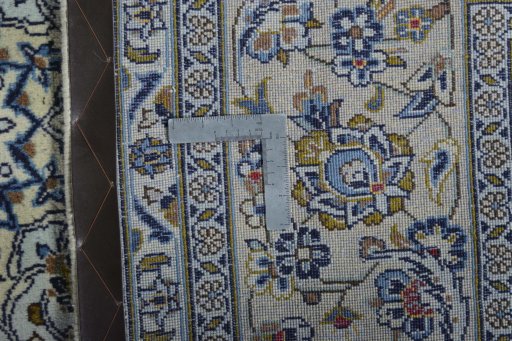 Backside of handmade New Kashan rug showing knot structure and weave density