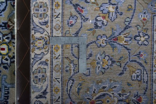 Backside of handmade 2000s Kashan rug showing knot structure and weave density