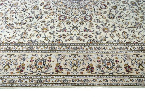 Corner detail of 2000s Kashan rug showing border pattern and Wool pile