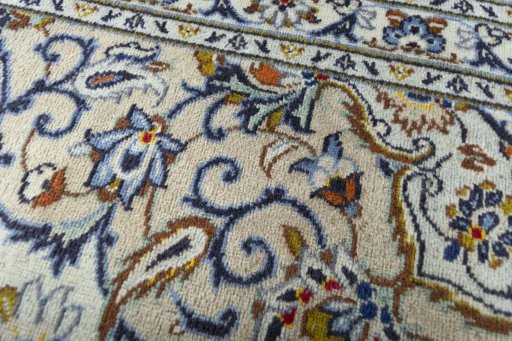 Corner detail of 2000s Kashan rug showing border pattern and Wool pile