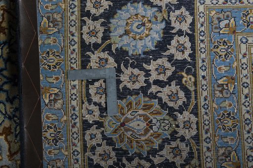 Backside of handmade 2000s Kashan rug showing knot structure and weave density