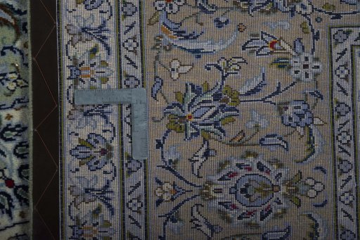 Backside of handmade 2000s Kashan rug showing knot structure and weave density