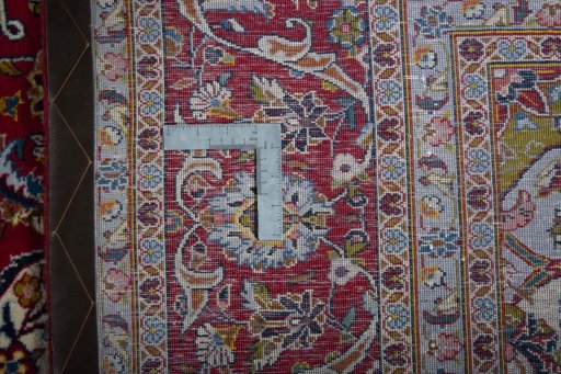 Backside of handmade New Kashan rug showing knot structure and weave density