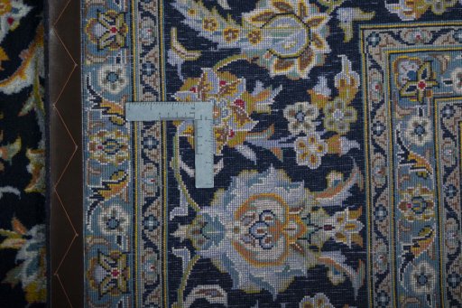 Backside of handmade 2000s Kashan rug showing knot structure and weave density