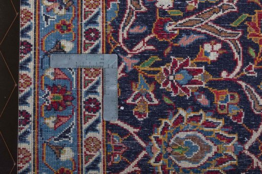 Backside of handmade 2000s Kashan rug showing knot structure and weave density