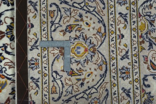 Backside of handmade 2000s Kashan rug showing knot structure and weave density