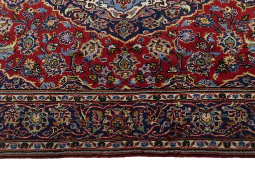 Corner detail of 2000s Kashan rug showing border pattern and Wool pile