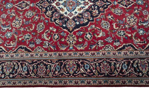 Corner detail of 2000s Kashan rug showing border pattern and Wool pile