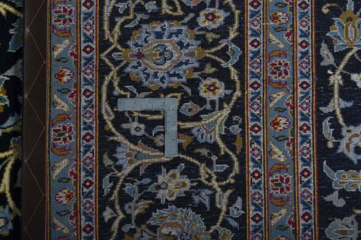 Backside of handmade 2000s Kashan rug showing knot structure and weave density