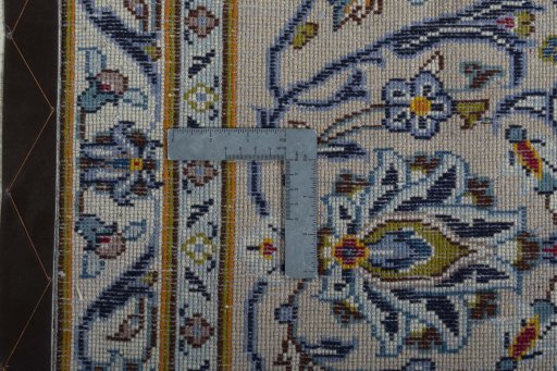 Backside of handmade 2000s Kashan rug showing knot structure and weave density