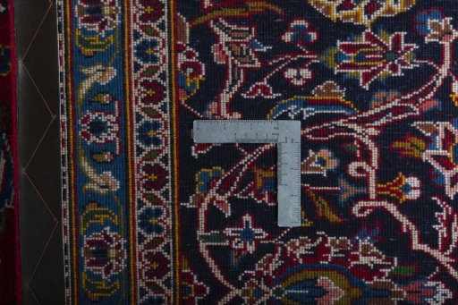 Backside of handmade 2000s Kashan rug showing knot structure and weave density