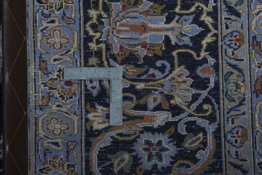 Backside of handmade 2000s Kashan rug showing knot structure and weave density