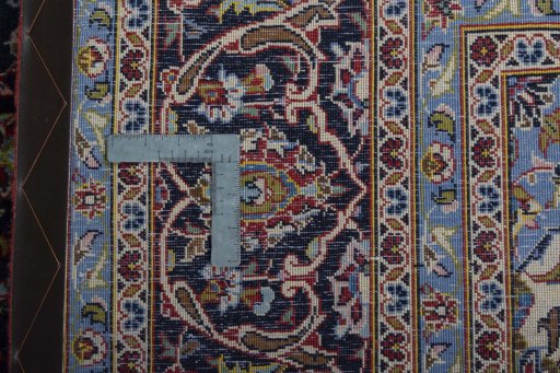 Backside of handmade 2000s Kashan rug showing knot structure and weave density