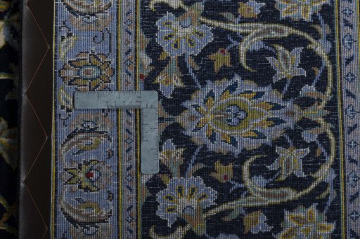 Backside of handmade 2000s Kashan rug showing knot structure and weave density