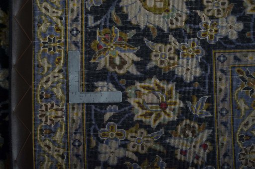 Backside of handmade 2000s Kashan rug showing knot structure and weave density