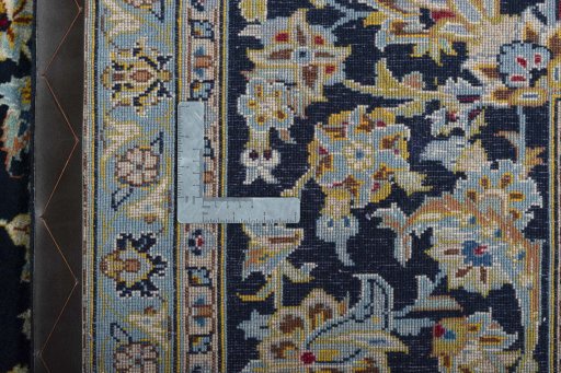 Backside of handmade 2000s Kashan rug showing knot structure and weave density