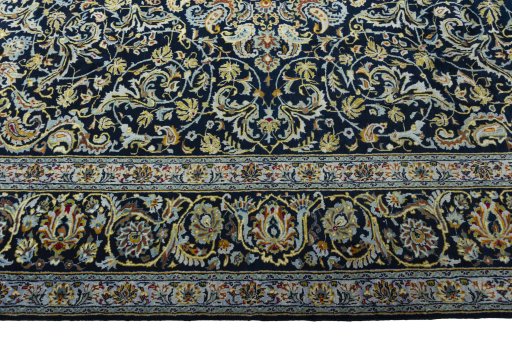 Corner detail of 2000s Kashan rug showing border pattern and Wool pile
