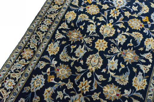 Backside of handmade 2000s Kashan rug showing knot structure and weave density