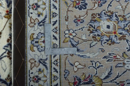 Backside of handmade 2000s Kashan rug showing knot structure and weave density
