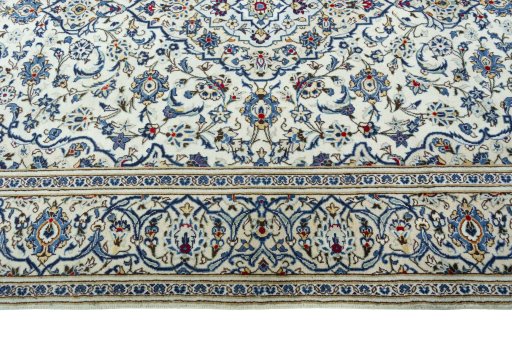 Corner detail of 2000s Kashan rug showing border pattern and Wool pile