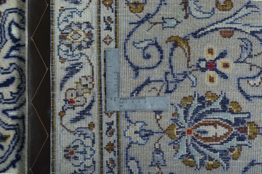 Backside of handmade 2000s Kashan rug showing knot structure and weave density