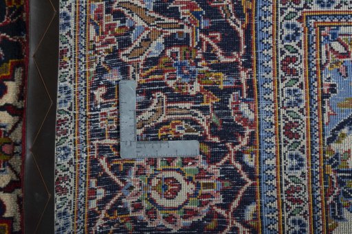 Backside of handmade 2000s Kashan rug showing knot structure and weave density