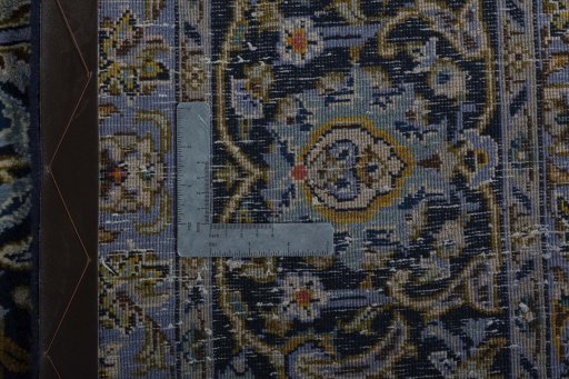Backside of handmade 2000s Kashan rug showing knot structure and weave density