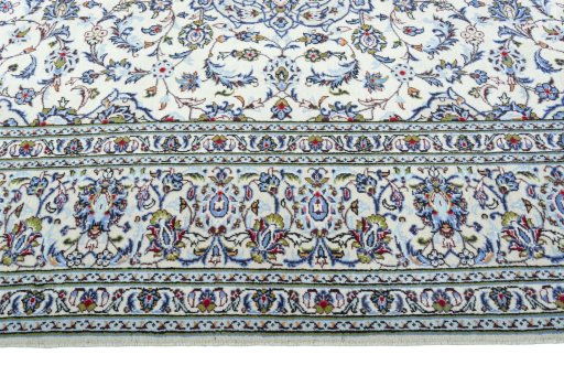 Corner detail of 2000s Kashan rug showing border pattern and Wool pile