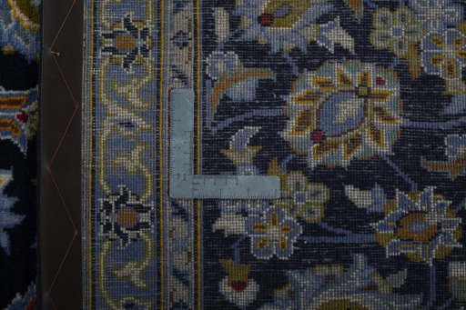 Backside of handmade 2000s Kashan rug showing knot structure and weave density