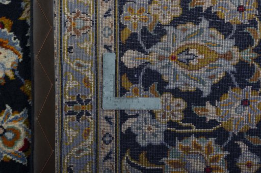 Backside of handmade 2000s Kashan rug showing knot structure and weave density