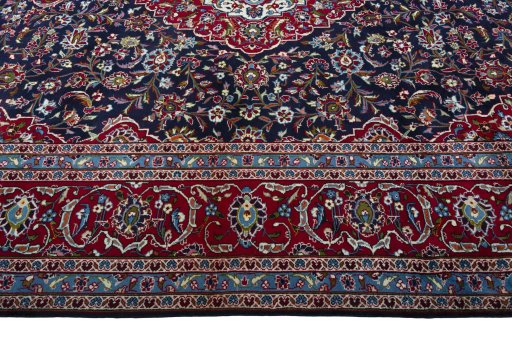 Corner detail of 2000s Kashan rug showing border pattern and Wool pile