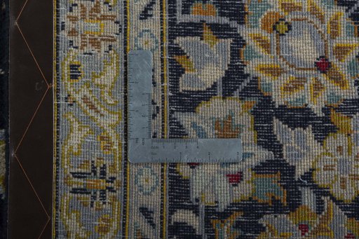 Backside of handmade 2000s Kashan rug showing knot structure and weave density