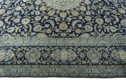 Corner detail of 2000s Kashan rug showing border pattern and Wool pile