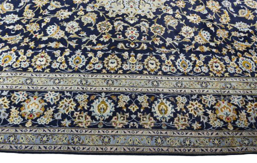 Corner detail of 2000s Kashan rug showing border pattern and Wool pile