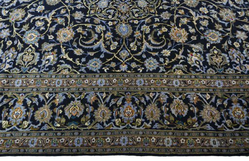 Corner detail of 2000s Kashan rug showing border pattern and Wool pile