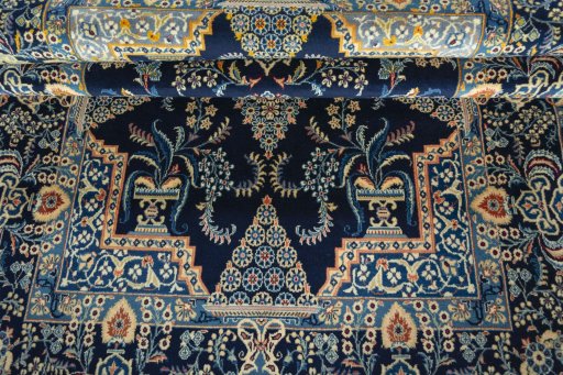 Corner detail of 2000s Kashan rug showing border pattern and Wool pile