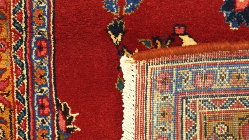 Corner detail of 2000s Mashad rug showing border pattern and Wool pile