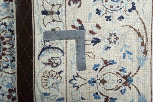 Backside of handmade New Nain rug showing knot structure and weave density