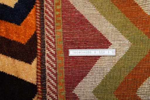 Corner detail of 2000s Persian Gabbeh rug showing border pattern and Wool pile