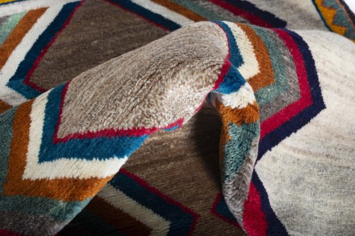 Corner detail of 2000s Persian Gabbeh rug showing border pattern and Wool pile