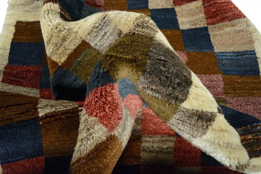 Corner detail of 2000s Persian Gabbeh rug showing border pattern and Wool pile